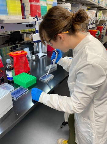 A woman piping samples in a lab