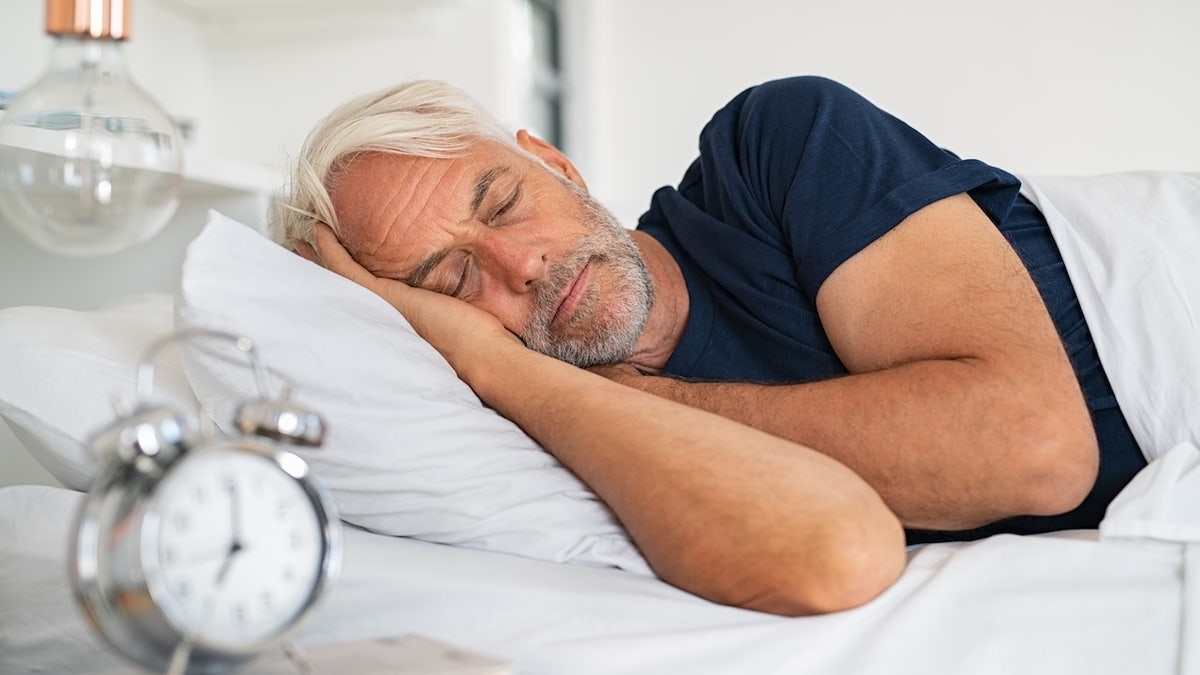 Older man sleeping in bed