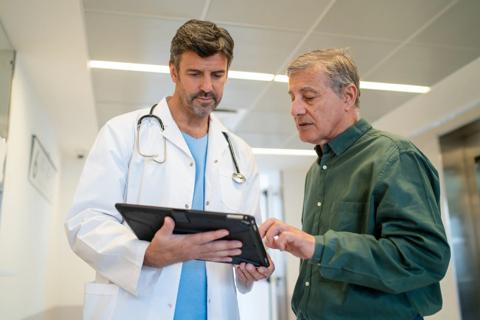 Healthcare provider going over chart on tablet with patient
