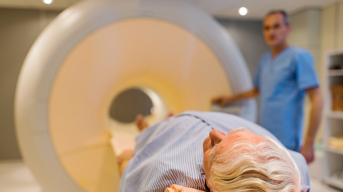 Senior male patient lying down at MRI scan.