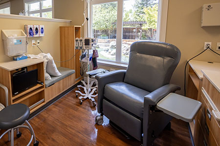 An infusion suite at a cancer center with medical chair near large windows
