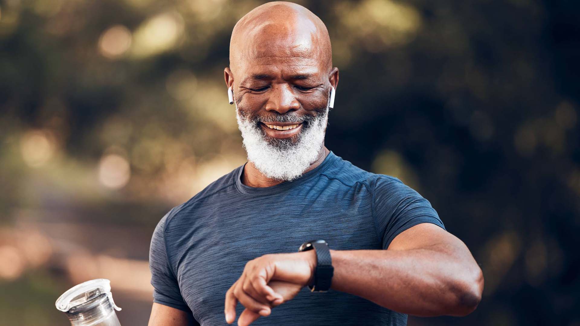 a man with a water bottle looking at his fitness watch