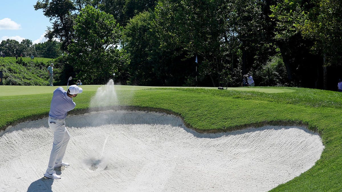 Scottie Scheffler hits from a bunker on the seventh hole.