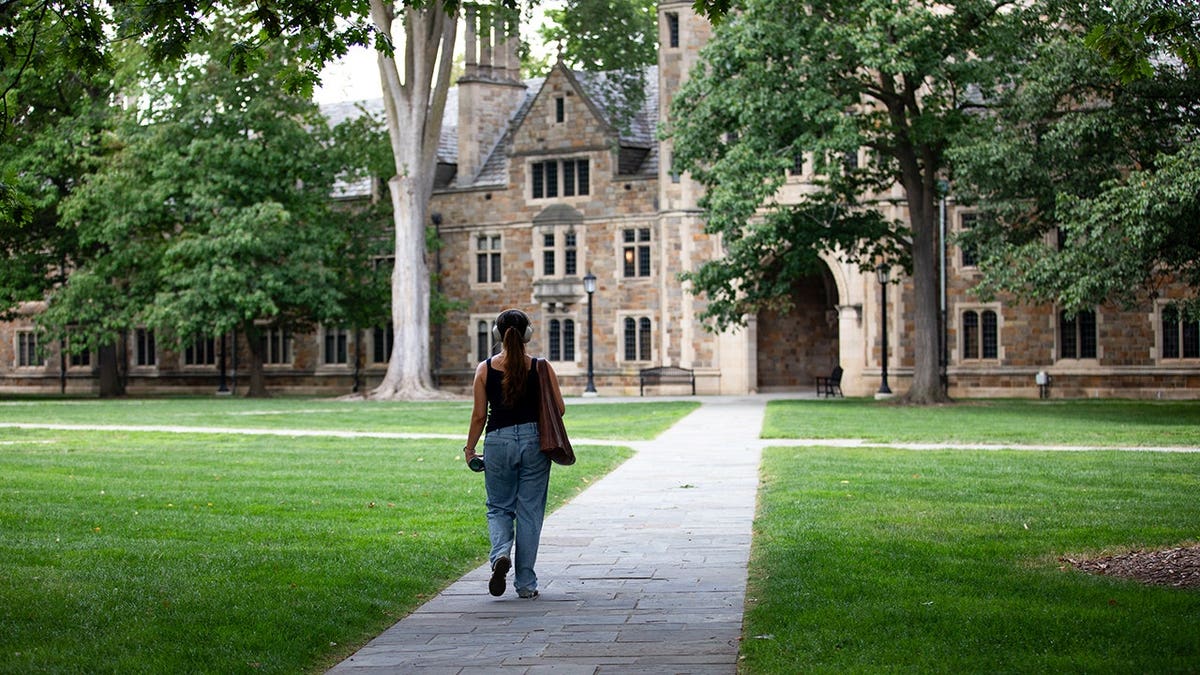 A student walks through the Law Quad at the University of Michigan.