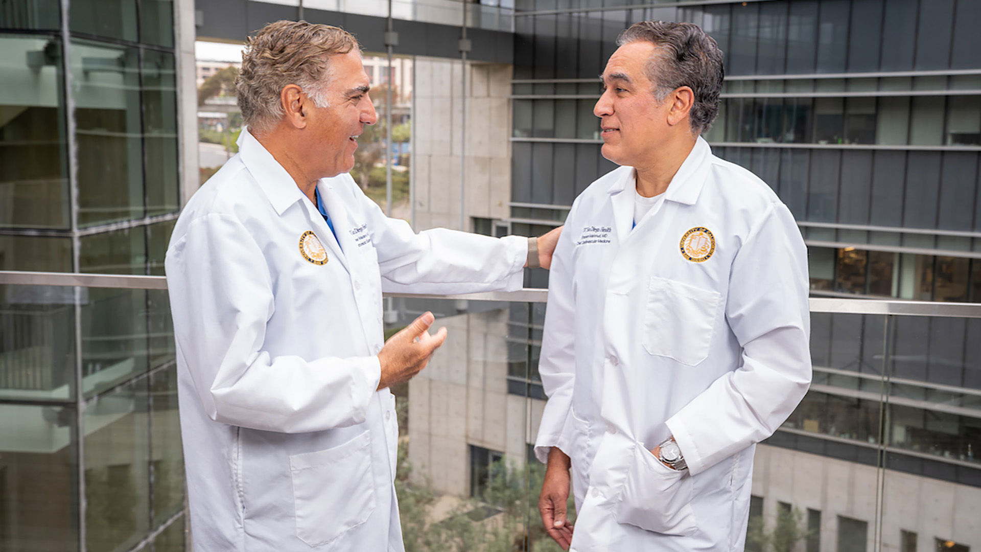Doctors Madani and Mahmud talking and smiling outside of Jacobs Medical Center.