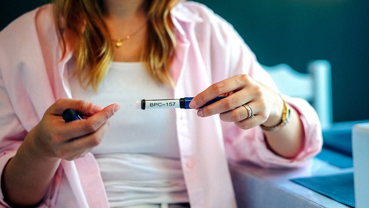 Woman holds a BPC-157 peptide injection pen.
