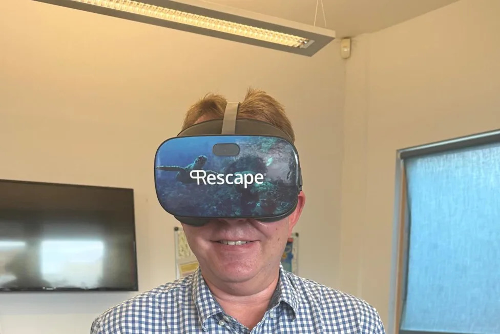 Professor Ollie Minton, Consultant in End of Life Care and Palliative Medicine at UHSussex and co-lead of the study, wearing the virtual reality (VR) technology used in the trial. (Image: UHSussex)