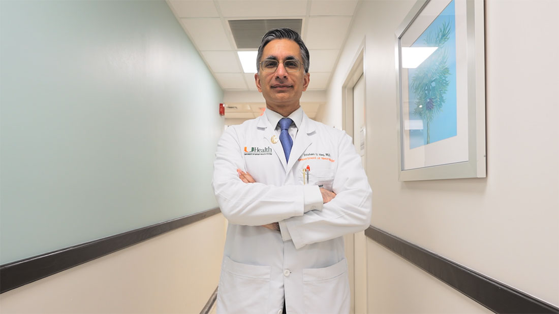 Dr. Ihtsham ul Haq, standing with his arms crossed in the hallway of a medical office
